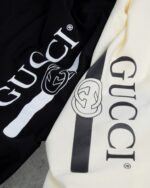 Gucci（グッチ） コピー 芸能人 ベルトロゴダブルgテーププリントラウンドネック半袖Tシャツ