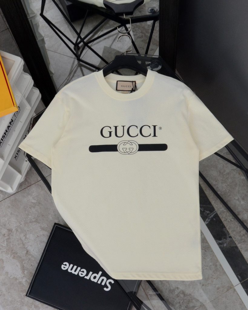 Gucci（グッチ） コピー 芸能人 ベルトロゴダブルgテーププリントラウンドネック半袖Tシャツ