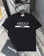 Gucci（グッチ） コピー 芸能人 ベルトロゴダブルgテーププリントラウンドネック半袖Tシャツ